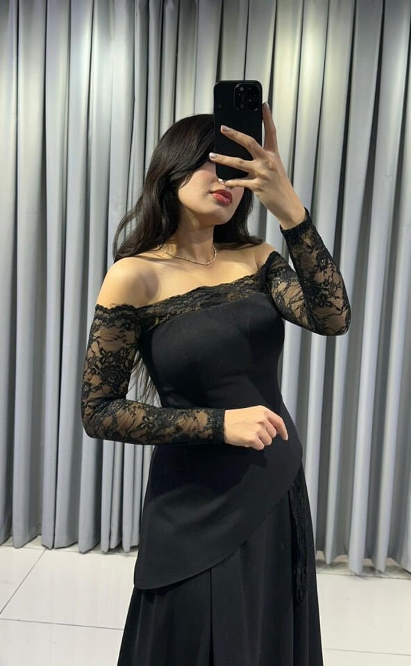 Omuzları açıkta bırakan (kayık yaka) ve uzun kolları dantel Katmanlı ve asimetrik kesimli uzun, dökümlü bir etek formuna Siyah Abiye elbise 38