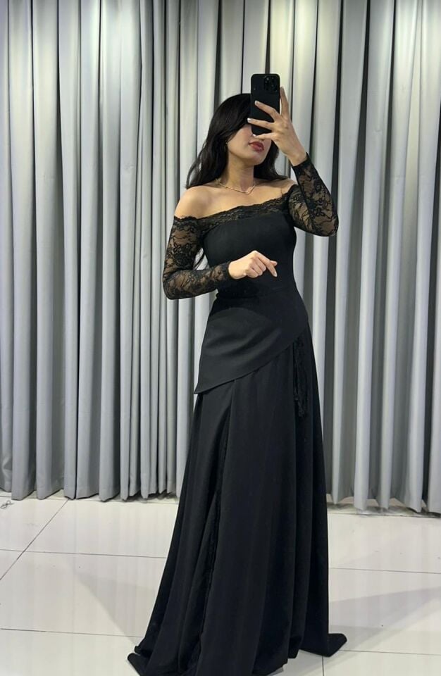 Omuzları açıkta bırakan (kayık yaka) ve uzun kolları dantel Katmanlı ve asimetrik kesimli uzun, dökümlü bir etek formuna Siyah Abiye elbise 44