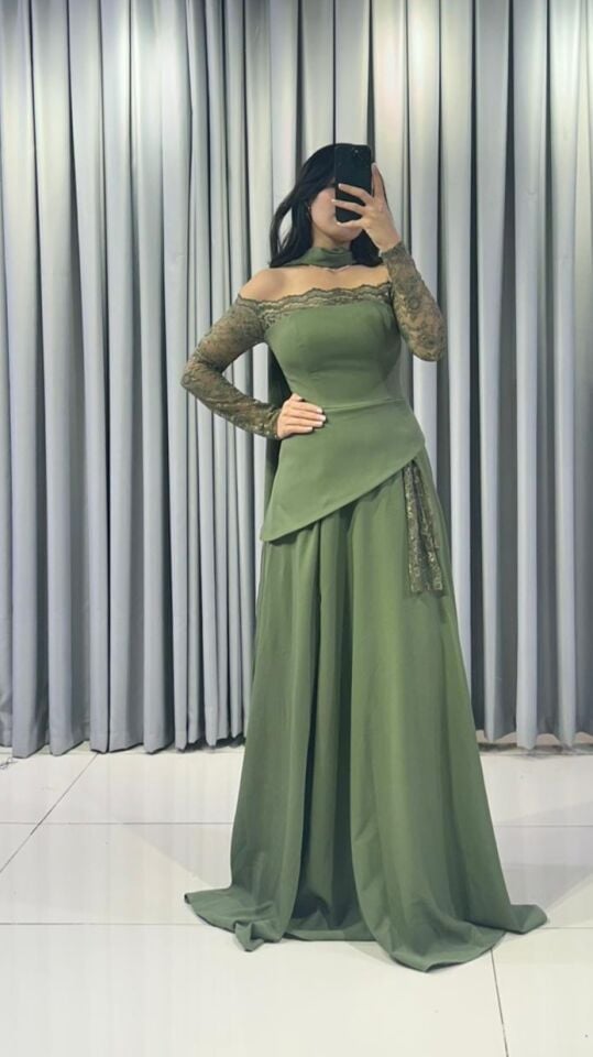 Omuzları açıkta bırakan (kayık yaka) ve uzun kolları dantel Katmanlı ve asimetrik kesimli uzun, dökümlü bir etek formuna  Yeşil Abiye elbise 44