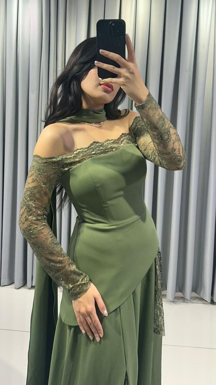 Omuzları açıkta bırakan (kayık yaka) ve uzun kolları dantel Katmanlı ve asimetrik kesimli uzun, dökümlü bir etek formuna  Yeşil Abiye elbise 44