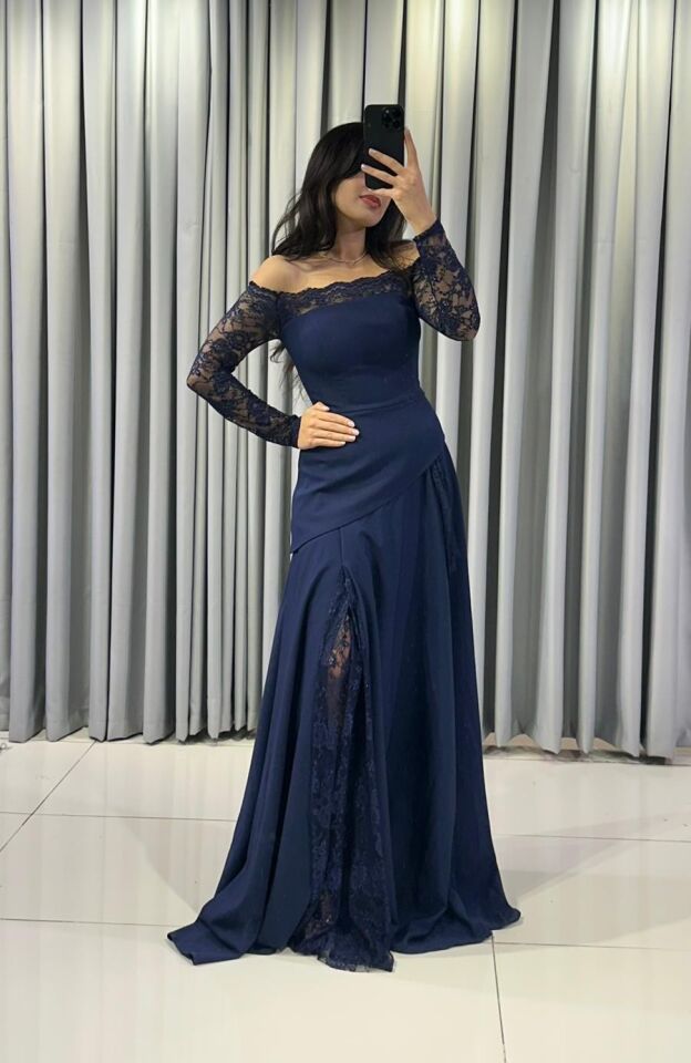 Omuzları açıkta bırakan (kayık yaka) ve uzun kolları dantel Katmanlı ve asimetrik kesimli uzun, dökümlü bir etek formuna  Lacivert Abiye elbise 44