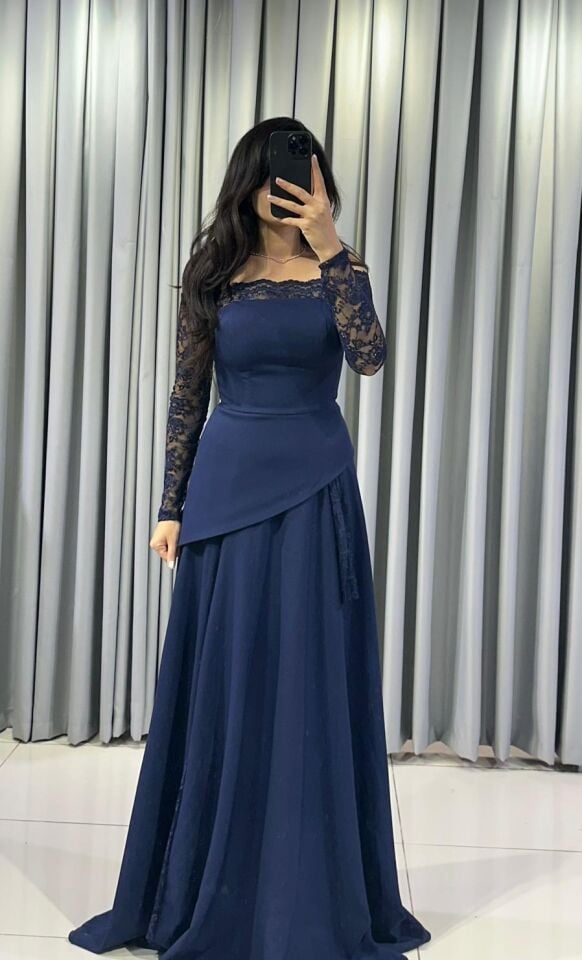 Omuzları açıkta bırakan (kayık yaka) ve uzun kolları dantel Katmanlı ve asimetrik kesimli uzun, dökümlü bir etek formuna  Lacivert Abiye elbise 44