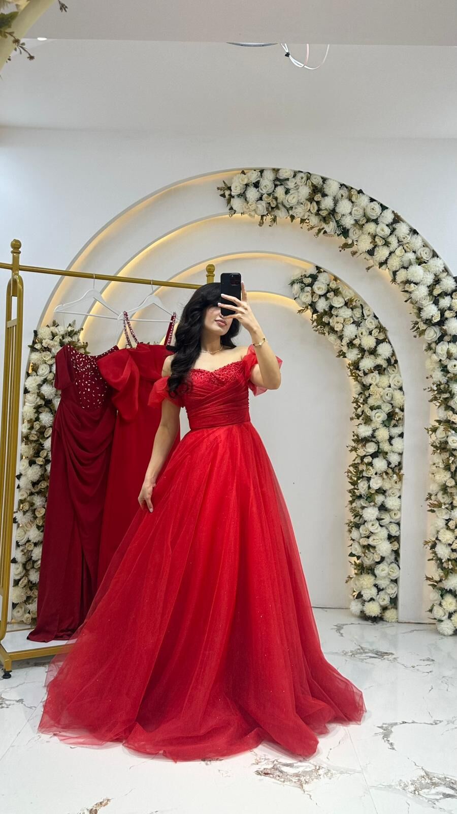 Kırmızı tül kumaştan yapılmış, kabarık etekli ve omuzları açık bir Kırmızı Abiye 42