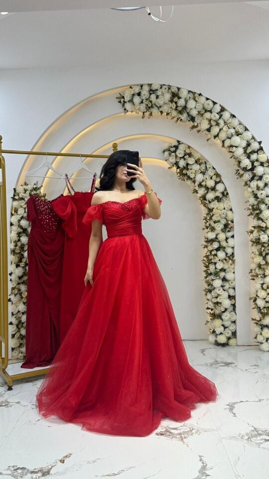 Kırmızı tül kumaştan yapılmış, kabarık etekli ve omuzları açık bir Kırmızı Abiye 42