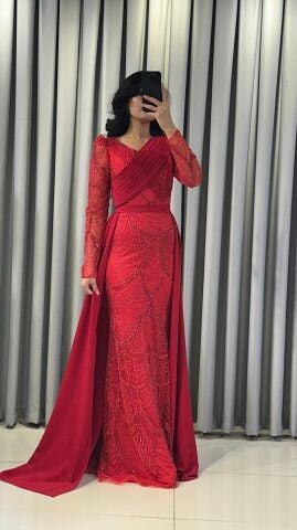 Uzun kollu, pullu ve payetli balık kesim Kırmızı Abiye elbise. Belden düşümlü, sade kumaştan uzun pelerin kuyruk detayı mevcuttur. 44