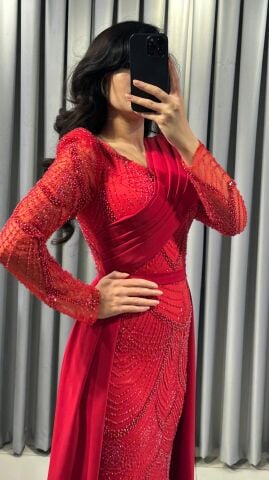 Uzun kollu, pullu ve payetli balık kesim Kırmızı Abiye elbise. Belden düşümlü, sade kumaştan uzun pelerin kuyruk detayı mevcuttur. 44