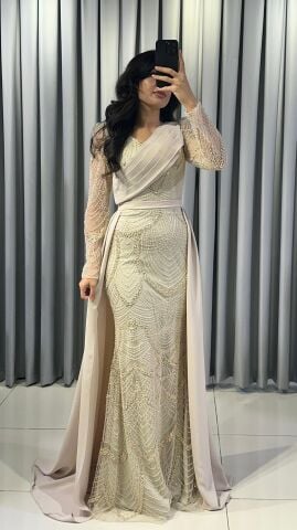 Uzun kollu, pullu ve payetli balık kesim Krem Abiye elbise. Belden düşümlü, sade kumaştan uzun pelerin kuyruk detayı mevcuttur. 44