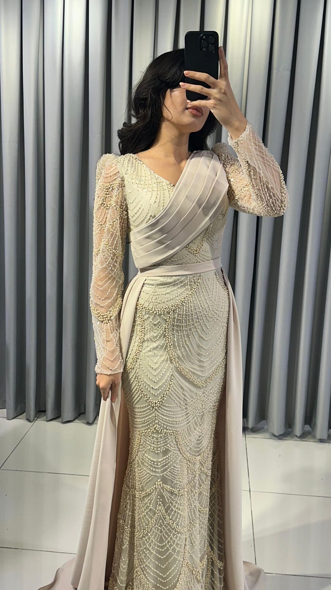 Uzun kollu, pullu ve payetli balık kesim Krem Abiye elbise. Belden düşümlü, sade kumaştan uzun pelerin kuyruk detayı mevcuttur. 44