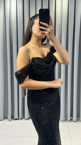 Omuzları açık vücuda oturan balık Göğüs kısmı ve korsaj, parlak boncuk pul işlemelerle yoğun bir şekilde süslü Ön kısımda yüksek yırtmaç Saten Siyah Abiye 44