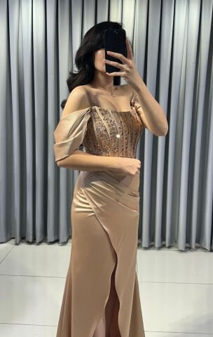 Omuzları açık vücuda oturan balık Göğüs kısmı ve korsaj, parlak boncuk pul işlemelerle yoğun bir şekilde süslü Ön kısımda yüksek yırtmaç Saten Gold Abiye 42