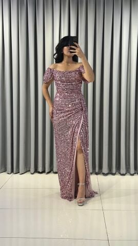 Baştan sona pullu ve payetli, parlak bir görünüme sahip Omuzları açık (kayık yaka veya düşük omuz) bir kesime sahip Bel ve kalça hizasında drapeli yüksek yırtmaç detaylı Pembe Abiye 42