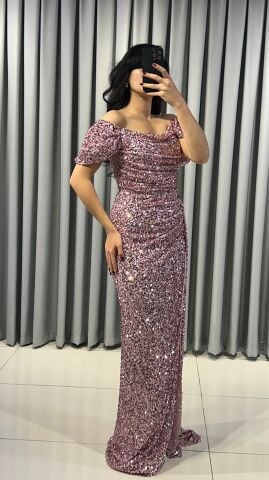 Baştan sona pullu ve payetli, parlak bir görünüme sahip Omuzları açık (kayık yaka veya düşük omuz) bir kesime sahip Bel ve kalça hizasında drapeli yüksek yırtmaç detaylı Pembe Abiye 42