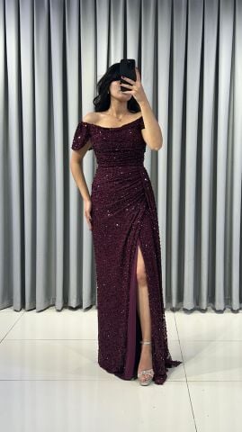 Baştan sona pullu ve payetli, parlak bir görünüme sahip Omuzları açık (kayık yaka veya düşük omuz) bir kesime sahip Bel ve kalça hizasında drapeli yüksek yırtmaç detaylı Bordo Abiye 42