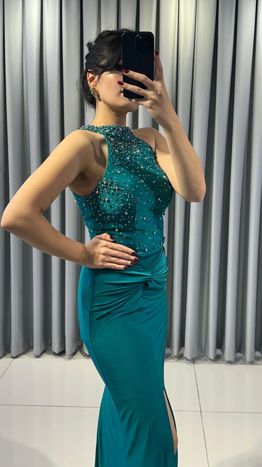 Halter yaka (yüksek, boyundan bağlamalı)Yoğun boncuk ve taş işlemeli (parlak/ışıltılı) Vücuda oturan, yüksek yırtmaçlı uzun etek Yırtmacın hemen üstünde büzgülü/düğüm görünümlü Yeşil Abiye 42