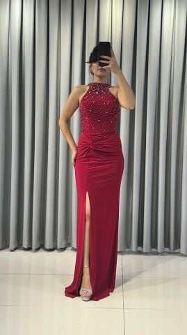 Halter yaka (yüksek, boyundan bağlamalı)Yoğun boncuk ve taş işlemeli (parlak/ışıltılı) Vücuda oturan, yüksek yırtmaçlı uzun etek Yırtmacın hemen üstünde büzgülü/düğüm görünümlü Kırmızı  Abiye 42