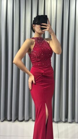 Halter yaka (yüksek, boyundan bağlamalı)Yoğun boncuk ve taş işlemeli (parlak/ışıltılı) Vücuda oturan, yüksek yırtmaçlı uzun etek Yırtmacın hemen üstünde büzgülü/düğüm görünümlü Kırmızı  Abiye 42 - Kırmızı