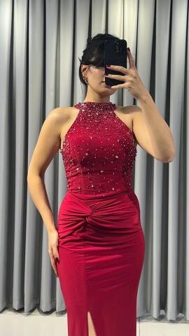 Halter yaka (yüksek, boyundan bağlamalı)Yoğun boncuk ve taş işlemeli (parlak/ışıltılı) Vücuda oturan, yüksek yırtmaçlı uzun etek Yırtmacın hemen üstünde büzgülü/düğüm görünümlü Kırmızı  Abiye 42