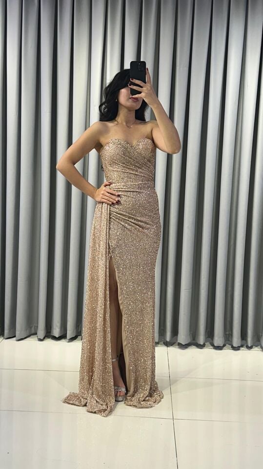 Baştan sona ışıltılı ve pullu Göğüs kısmında büzgülü ve vücudu saran kesim; yan kısımda, yırtmacın hemen yanında toplanmış, asimetrik bir etek detaylı Bej  Abiye 40