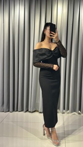 Omuzları açık (straplez/kayık yaka) ve büst kısmında fiyonk veya büzgü detayı olan, midi/uzun boy dar kesim Kolları siyah dantel veya şeffaf, desenli tül abiye elbise 42