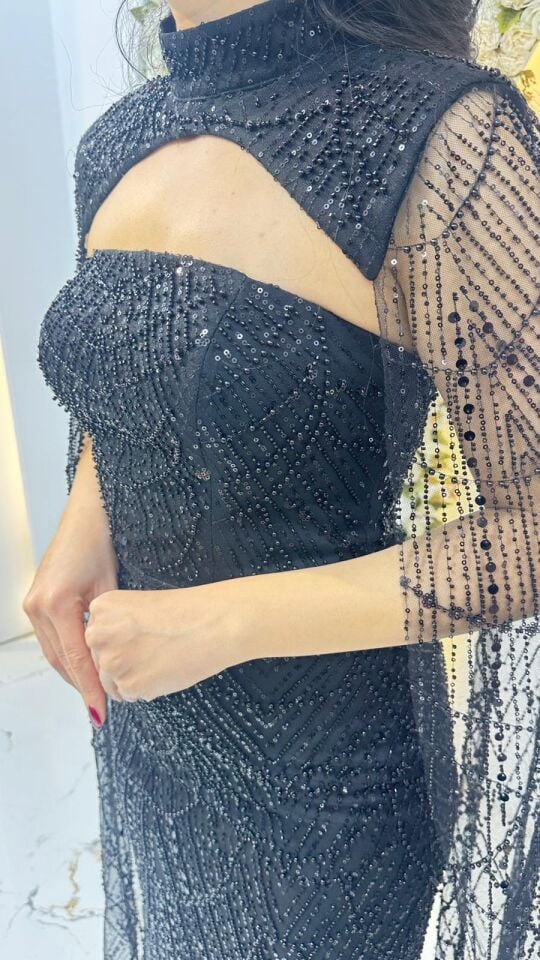 Elbisenin tamamı ışıltılı payet ve taş yaka tasarımı ve omuzlardan aşağı süzülen tül pelerin detayına sahip Siyah Abiye 42