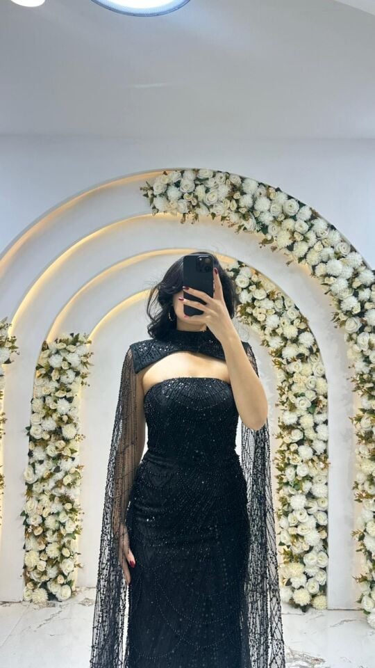 Elbisenin tamamı ışıltılı payet ve taş yaka tasarımı ve omuzlardan aşağı süzülen tül pelerin detayına sahip Siyah Abiye 42