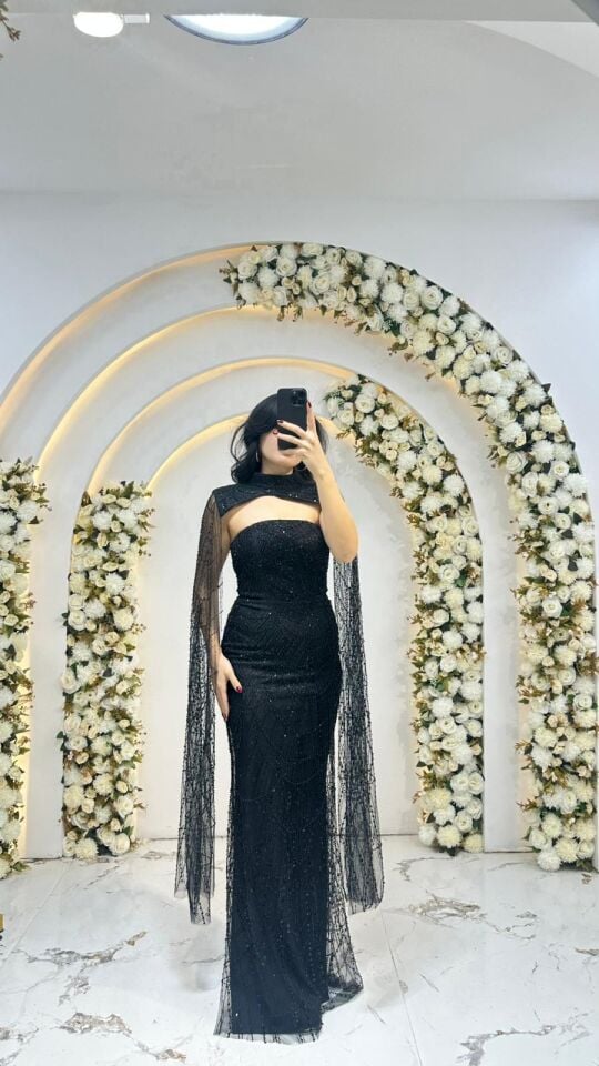 Elbisenin tamamı ışıltılı payet ve taş yaka tasarımı ve omuzlardan aşağı süzülen tül pelerin detayına sahip Siyah Abiye 42