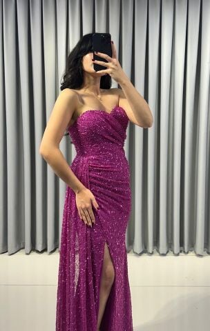 Baştan sona ışıltılı ve pullu Göğüs kısmında büzgülü ve vücudu saran kesim; yan kısımda, yırtmacın hemen yanında toplanmış, asimetrik bir etek detaylı  Fuşya Abiye 40