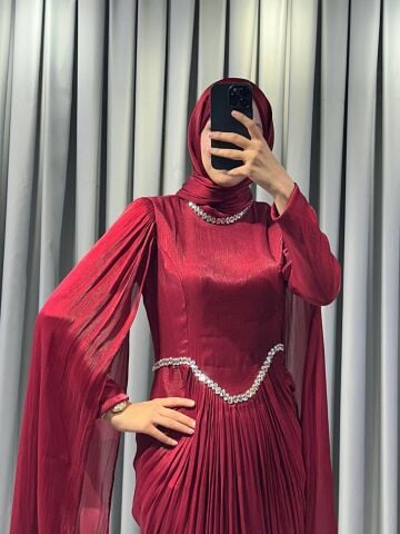 Uzun pelerin kollu, taş detaylı kemerli ve pileli Bordo Tesettür Abiye elbisedir. 44