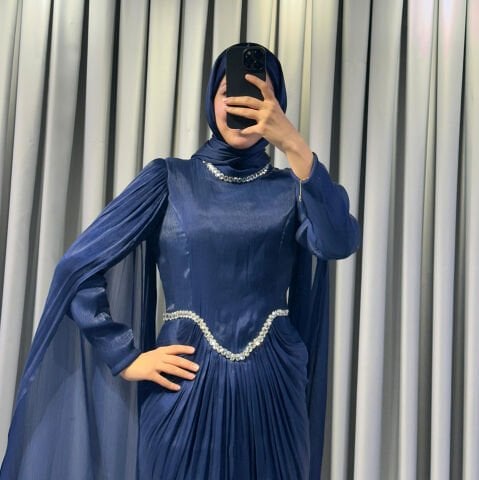 Uzun pelerin kollu, taş detaylı kemerli ve pileli Mavi Tesettür Abiye elbisedir. 44