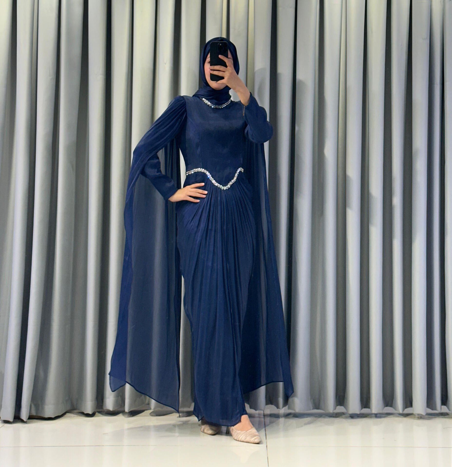 Uzun pelerin kollu, taş detaylı kemerli ve pileli Mavi Tesettür Abiye elbisedir. 38 - Mavi