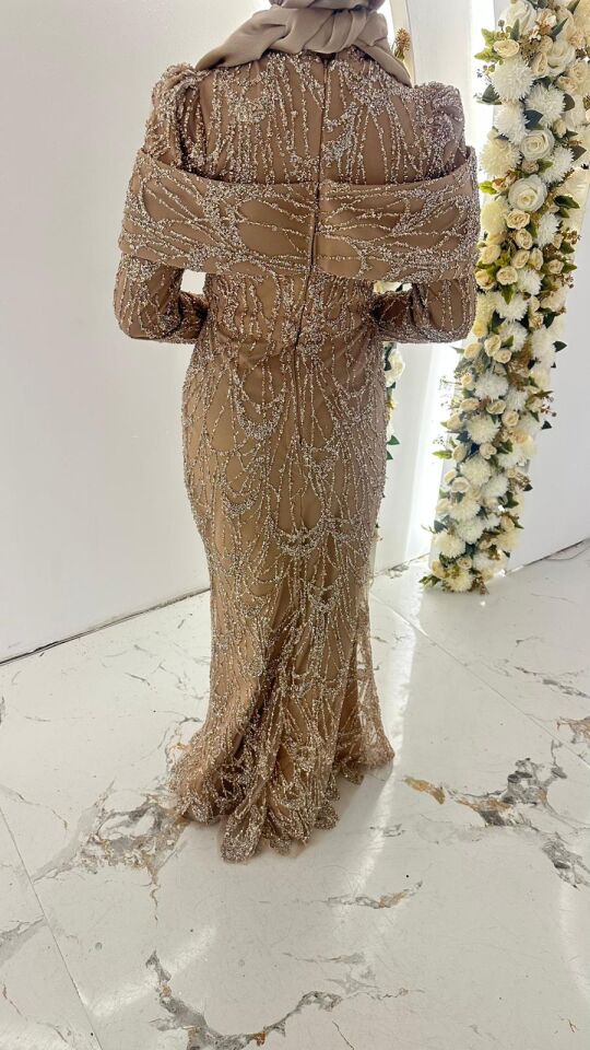 Vücuda oturan balık kesim formunda, uzun kollu ve hakim yaka detaylı kristal taş işlemeli Vizon Abiye