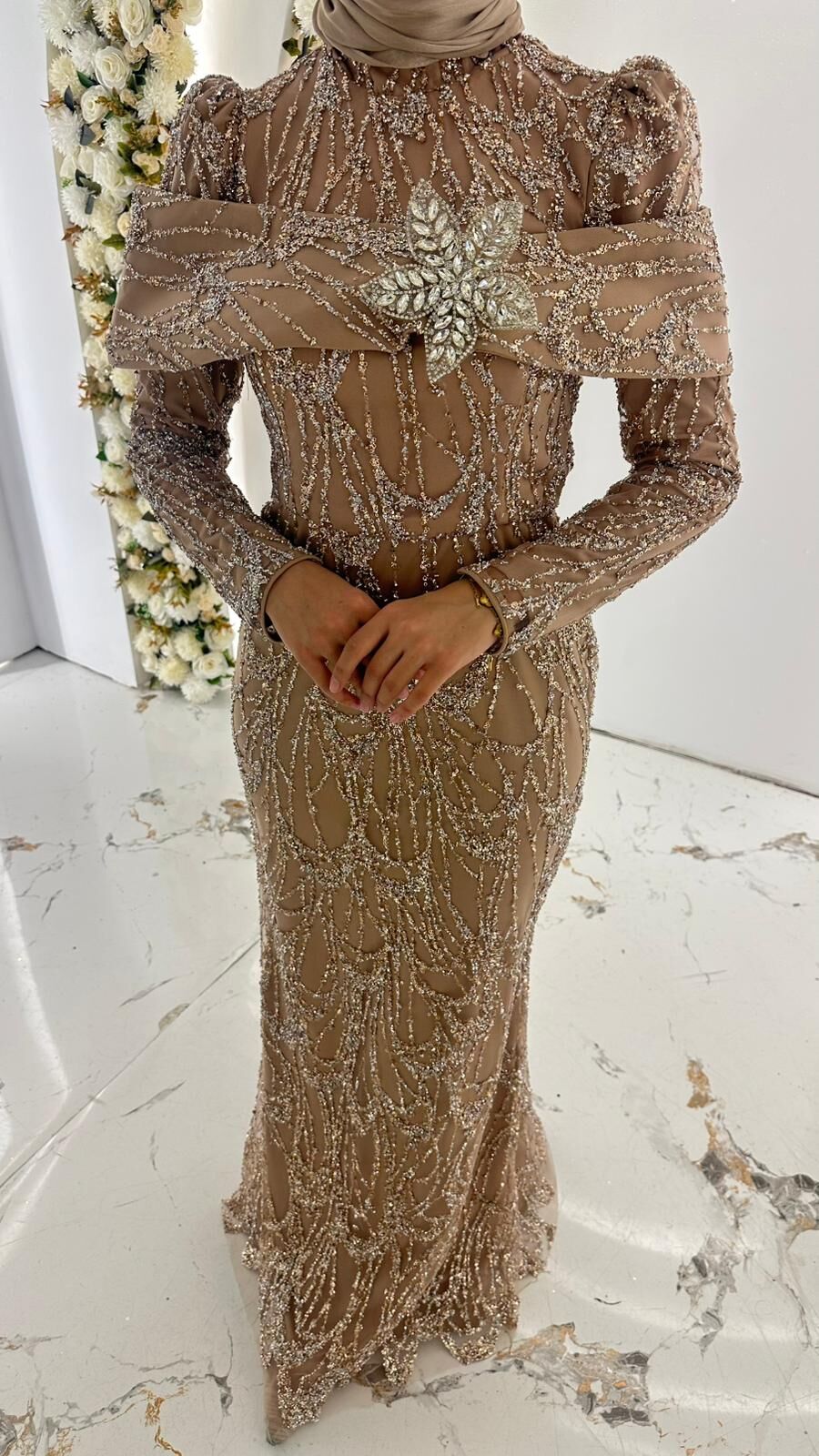 Vücuda oturan balık kesim formunda, uzun kollu ve hakim yaka detaylı kristal taş işlemeli Vizon Abiye