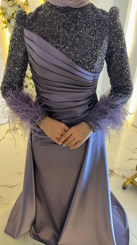 Gövde kısmında ışığı yansıtan saten kumaş, üst kısmında ise parıltılı pul payet bilek kısmı yoğun tül Belden aşağıya doğru dökümlü inen, kalça kısmında zarif Parlement Mavisi Balık Tesettür Abiye 42