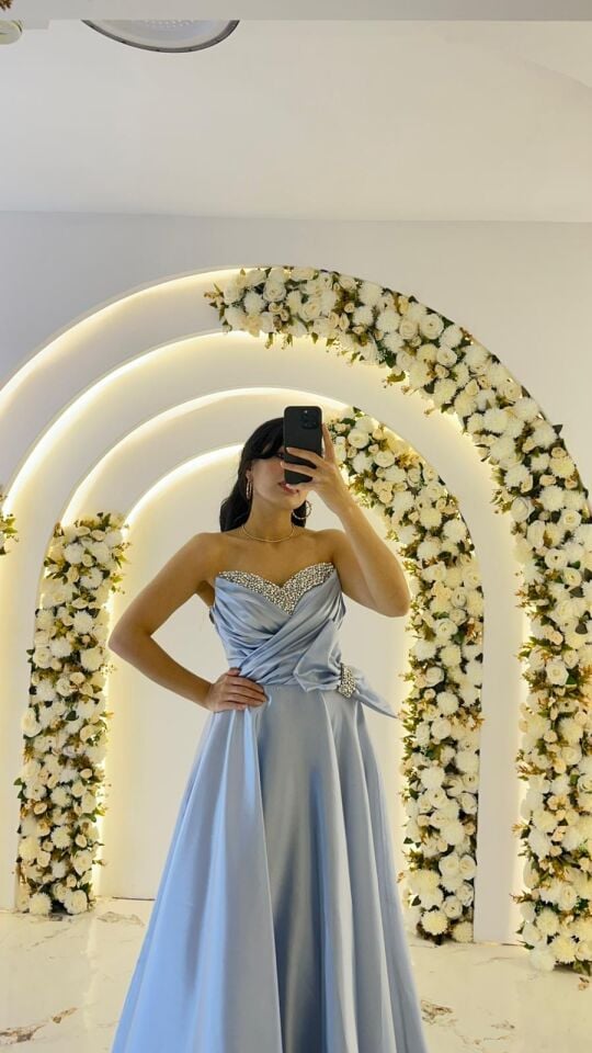 Kalp yaka kesimi üzerinde gümüş rengi taş ve boncuk işlemeleri Bel kısmında büyük, gösterişli bir fiyonk ve taşlı toka detayı mevcuttur A kesim prenses model Buz mavisi  Abiye 44