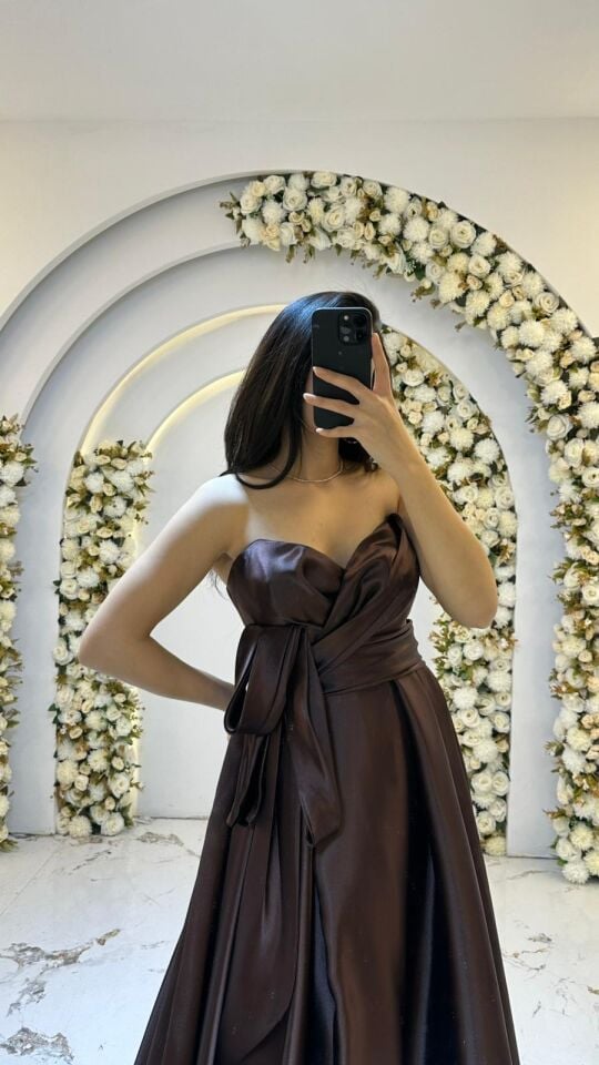 Straplez, kalp yaka kesimi Göğüs kısmında modern bir düğüm ve kuşak detayıyla hareketlendirilmiş bel hattı Kahverengi Abiye 42