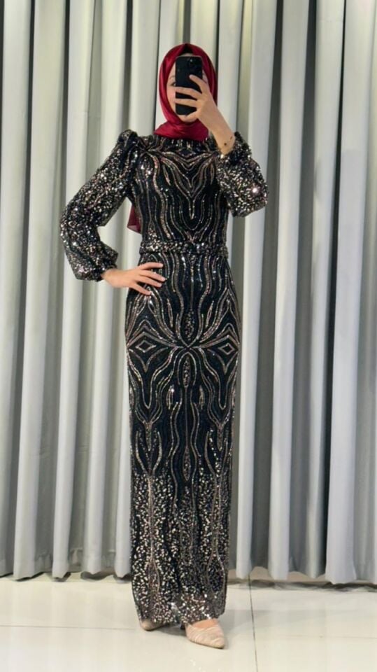 Pullu ve payetli Vücuda oturan, balık kesim Parlak, gümüş-siyah tonlarında yoğun pul ve payet işlemeleri bulunur Omuzları hafif kabarık Siyah Abiye