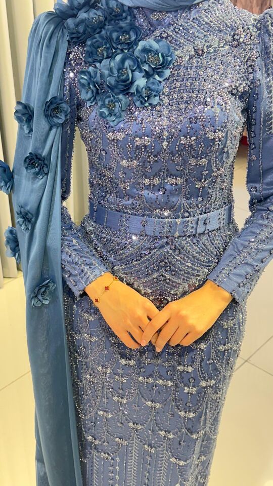 Baştan ayağa boncuk ve pul işlemeleri ile yoğun süslemeli Yüksek yaka Omuzdan başlayıp bele ve yere kadar uzanan, 3D çiçek aplikeleriyle süslü uzun bir şal/pelerin detayı bulunan Vücuda oturan, balık model Mind Yeşili Abiye 44