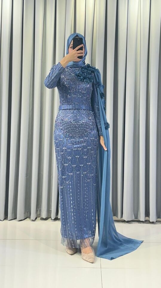 Baştan ayağa boncuk ve pul işlemeleri ile yoğun süslemeli Yüksek yaka Omuzdan başlayıp bele ve yere kadar uzanan, 3D çiçek aplikeleriyle süslü uzun bir şal/pelerin detayı bulunan Vücuda oturan, balık model Mind Yeşili Abiye 44