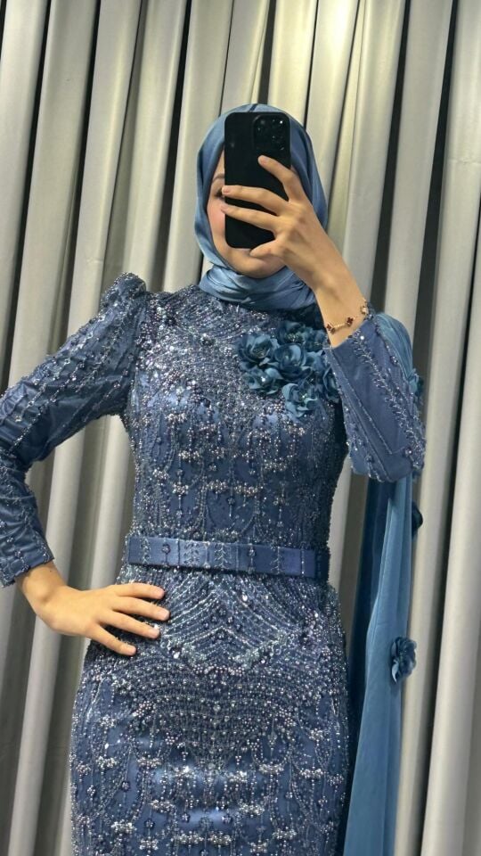 Baştan ayağa boncuk ve pul işlemeleri ile yoğun süslemeli Yüksek yaka Omuzdan başlayıp bele ve yere kadar uzanan, 3D çiçek aplikeleriyle süslü uzun bir şal/pelerin detayı bulunan Vücuda oturan, balık model Mind Yeşili Abiye 44