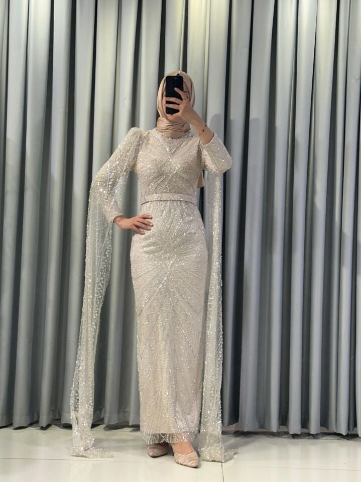 Kristal taş işlemeli Vücuda oturan, balık kesim Parlak,  yoğun pul ve payet işlemeleri bulunur Omuzları hafif kabarık Krem Abiye 48