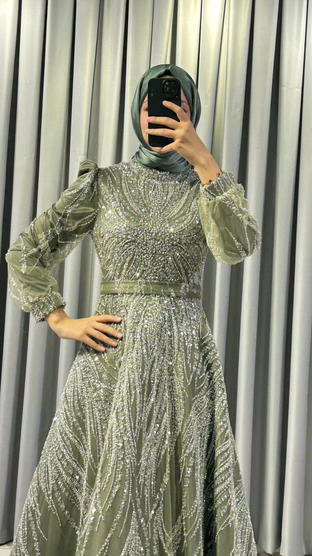 Uzun kollu,Baştan aşağı, dalgalı ve akıcı desenler oluşturan yoğun gümüş rengi payet ve boncuk işlemelere sahip Yüksek, hafif dik yaka Haki Yeşili Abiye