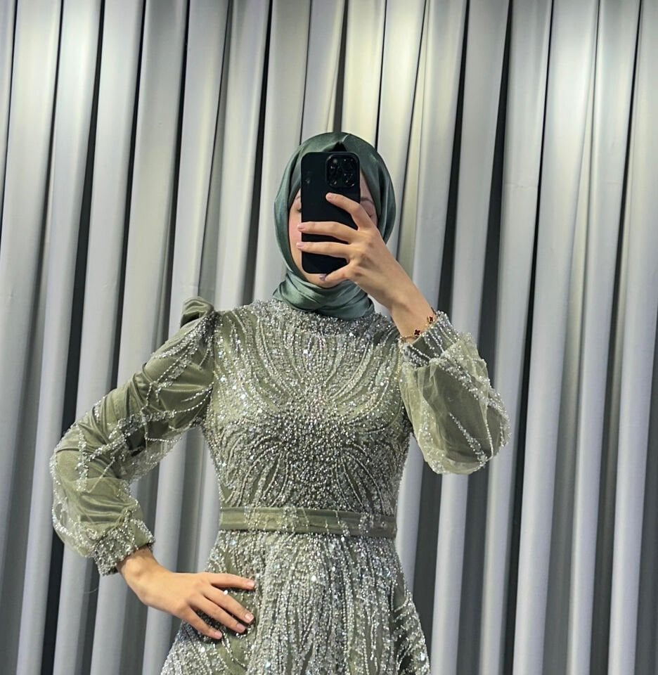 Uzun kollu,Baştan aşağı, dalgalı ve akıcı desenler oluşturan yoğun gümüş rengi payet ve boncuk işlemelere sahip Yüksek, hafif dik yaka Haki Yeşili Abiye