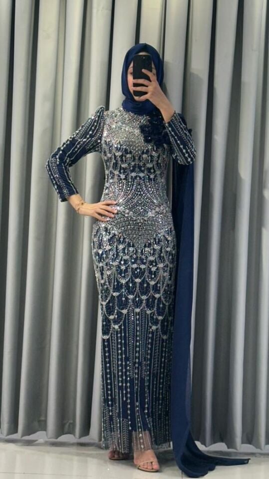 Baştan ayağa boncuk ve pul işlemeleri ile yoğun süslemeli Yüksek yaka Omuzdan başlayıp bele ve yere kadar uzanan, 3D çiçek aplikeleriyle süslü uzun bir şal/pelerin detayı bulunan Vücuda oturan, balık model Lacivert Abiye 44