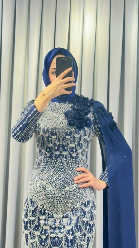 Baştan ayağa boncuk ve pul işlemeleri ile yoğun süslemeli Yüksek yaka Omuzdan başlayıp bele ve yere kadar uzanan, 3D çiçek aplikeleriyle süslü uzun bir şal/pelerin detayı bulunan Vücuda oturan, balık model Lacivert Abiye 38